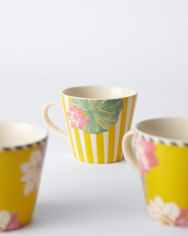 A mug with yellow stripes, a lily pad and a lotus