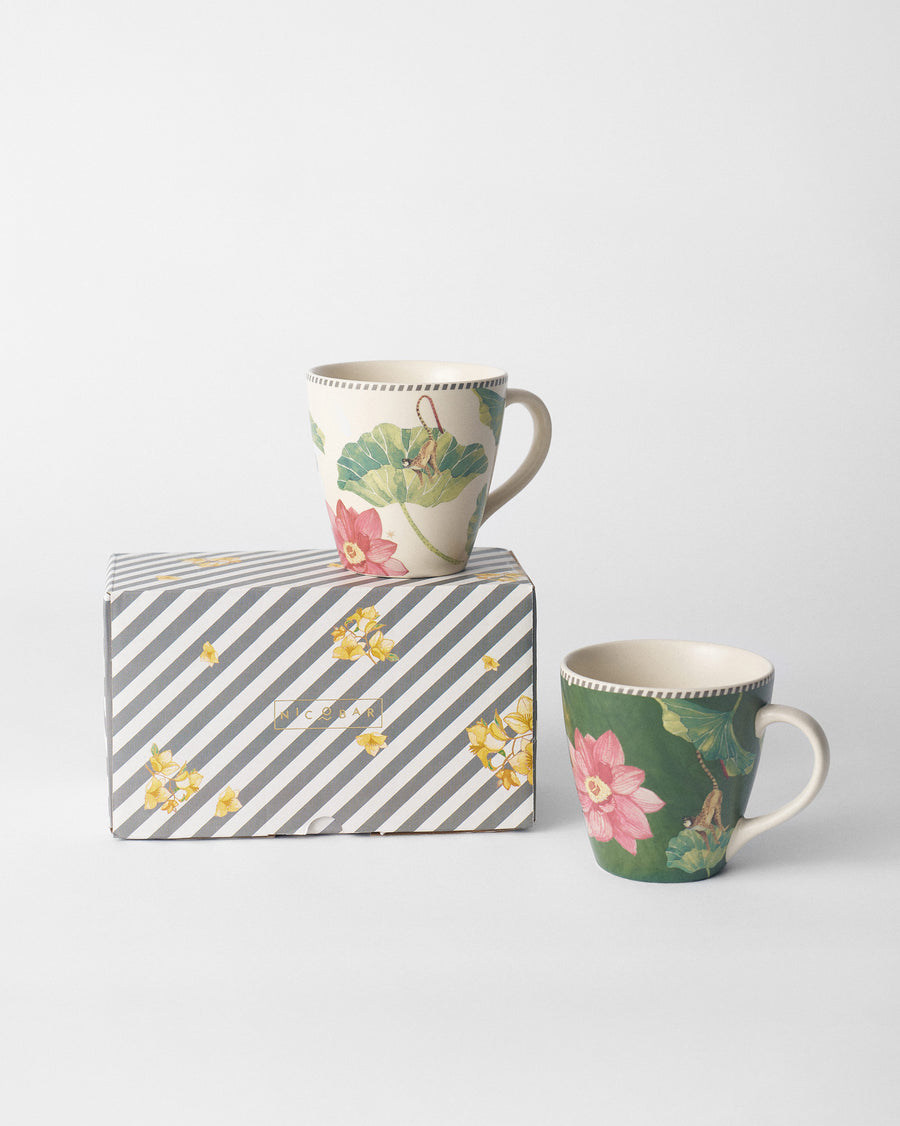 The mugs on and beside a striped gift box