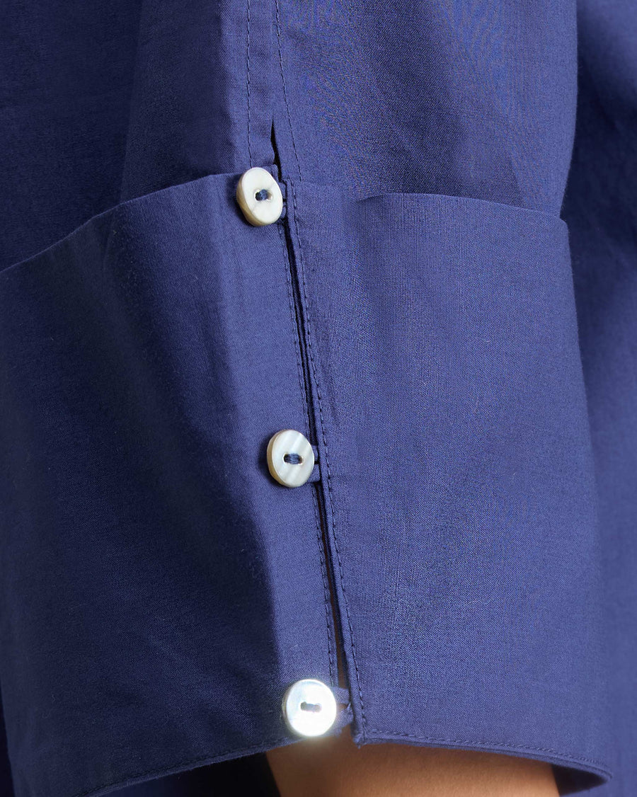 Close-up of the cuff: three buttons on ink blue poplin.