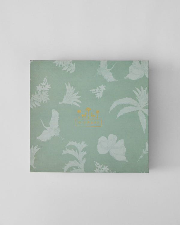 The closed sage box with a crane print and gold logo