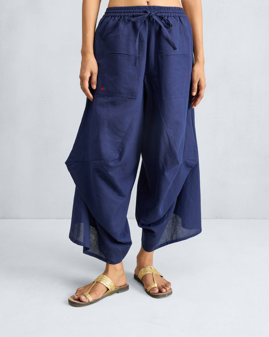 Yoka Trousers in ink blue, with a draped leg.