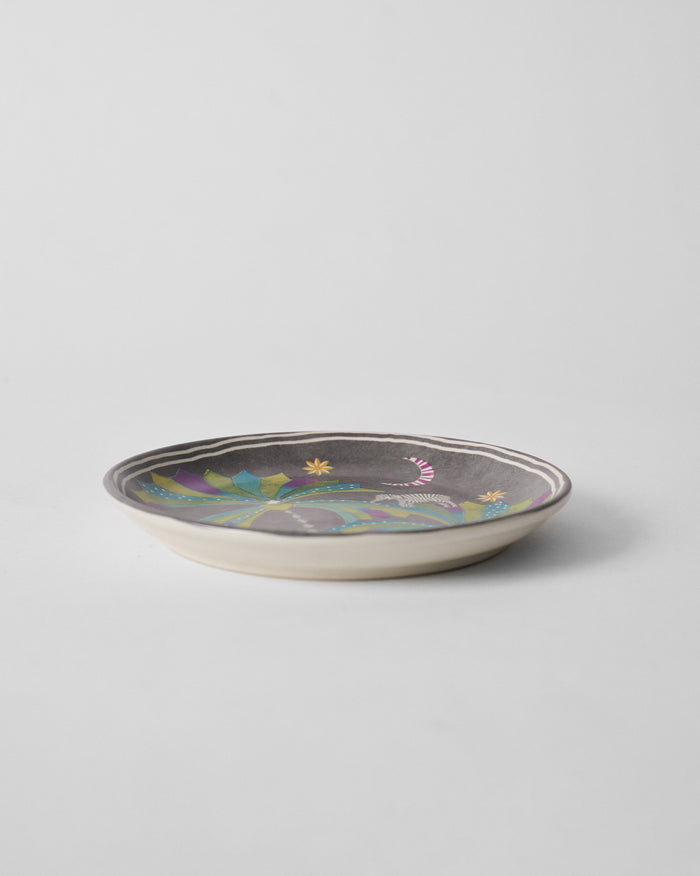 Side view of Palm Bloom quarter plate in grey with green and purple leaves.