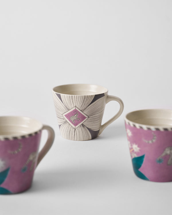 A cream mug with charcoal flowers and a magenta diamond