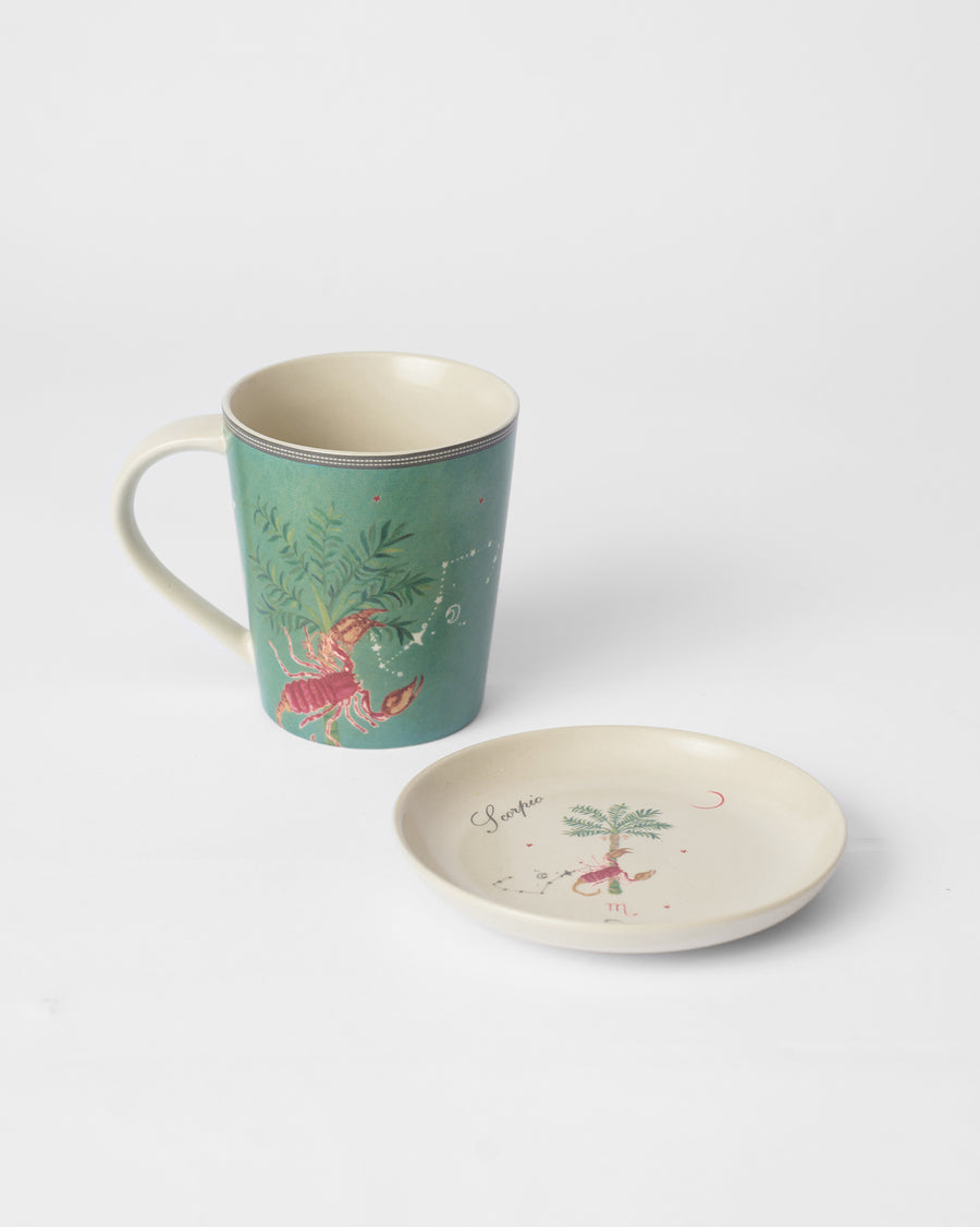 The teal Scorpio mug beside its tea plate
