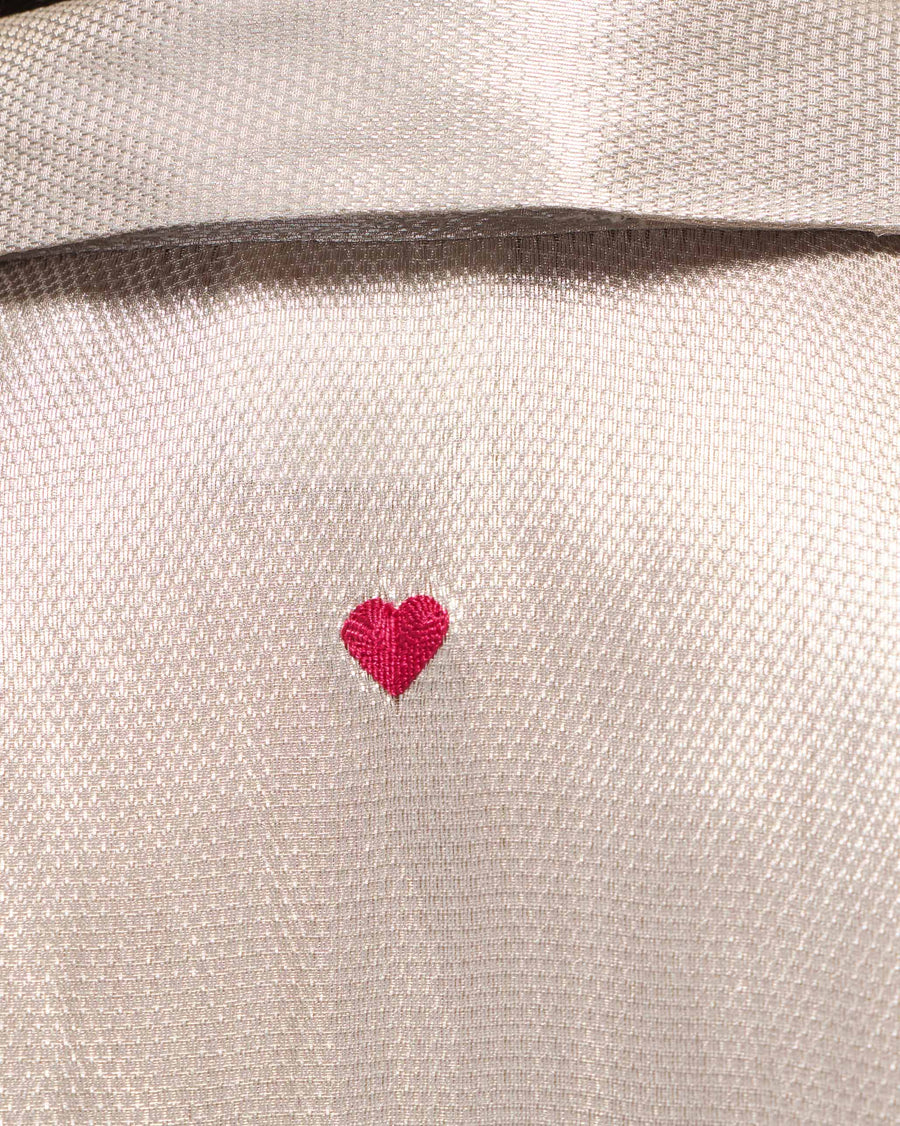 Close-up of a tiny red heart embroidered at the centre back of the Starlight Shirt, below the collar.