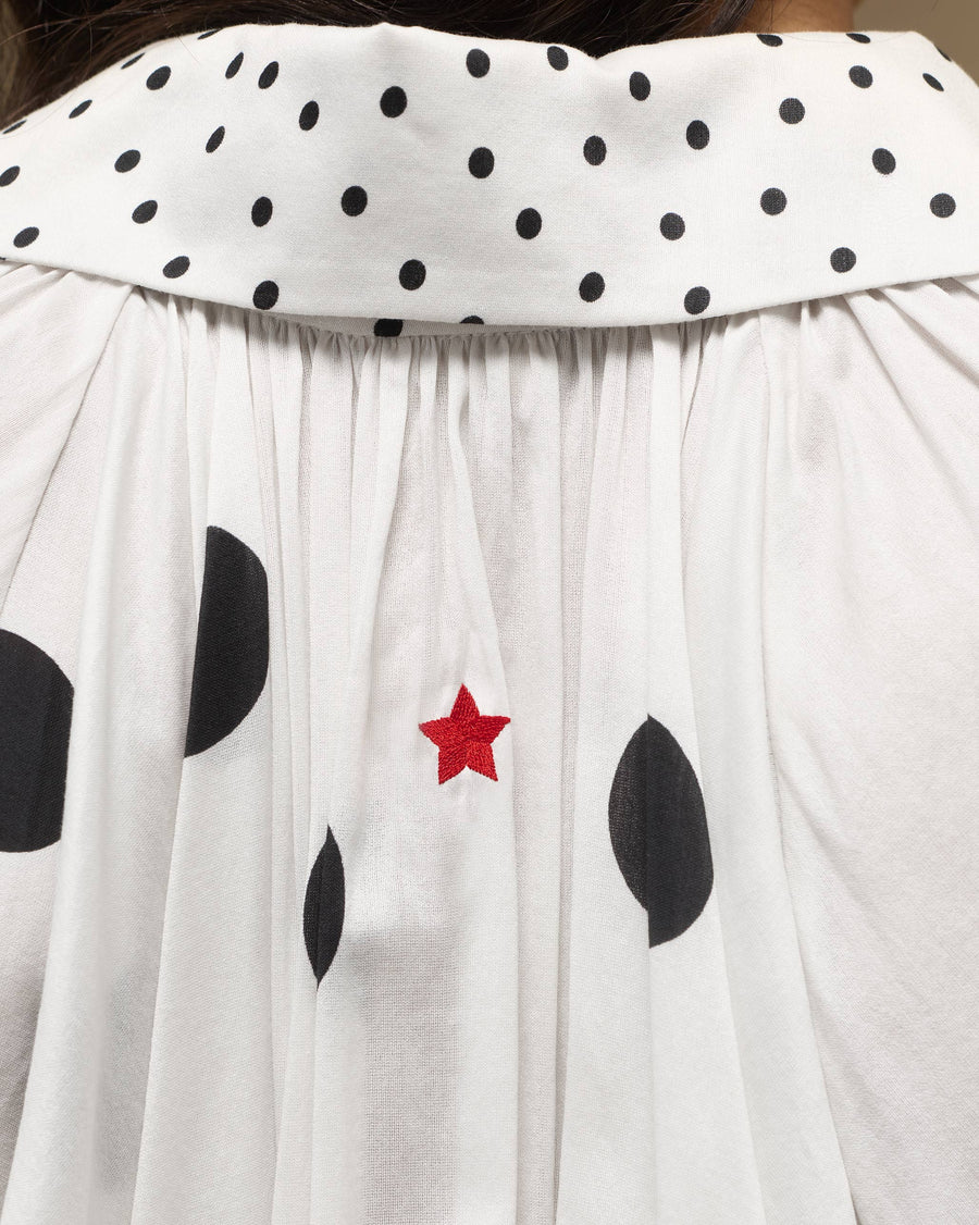 Close-up of a tiny red star embroidered at the centre back of the Cloud Overlay, below the small-dot collar.