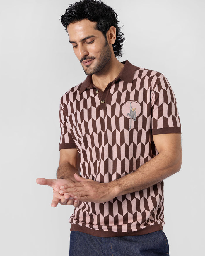 Person wearing a brown-and-pink Langur polo with a monkey chest motif.