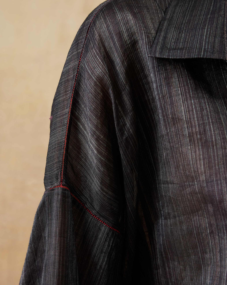 Close-up of the shoulder of the Firefly Shirt, showing red thread fagotting on black metallic tissue.