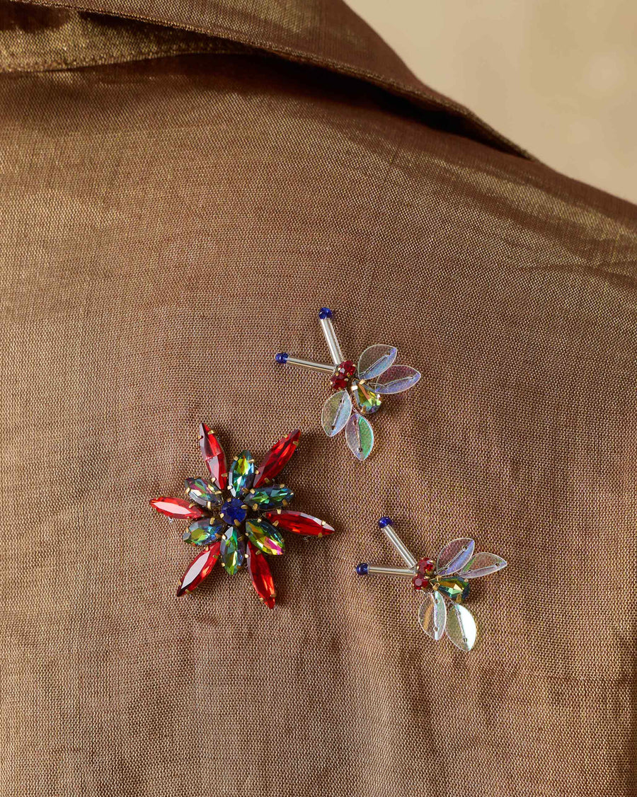 Close-up of the stone bug embroidery on the back of the Golden Hour Shirt, in red, green and clear stones.