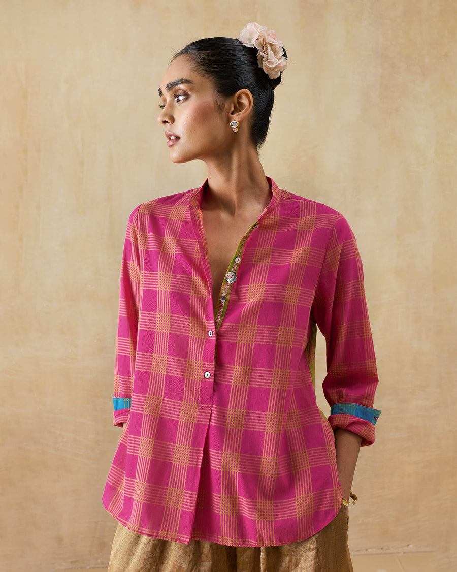 The Mandarin Collar Top, a berry and lime checked cotton top with a mandarin collar and rolled cuffs, worn with gold trousers.