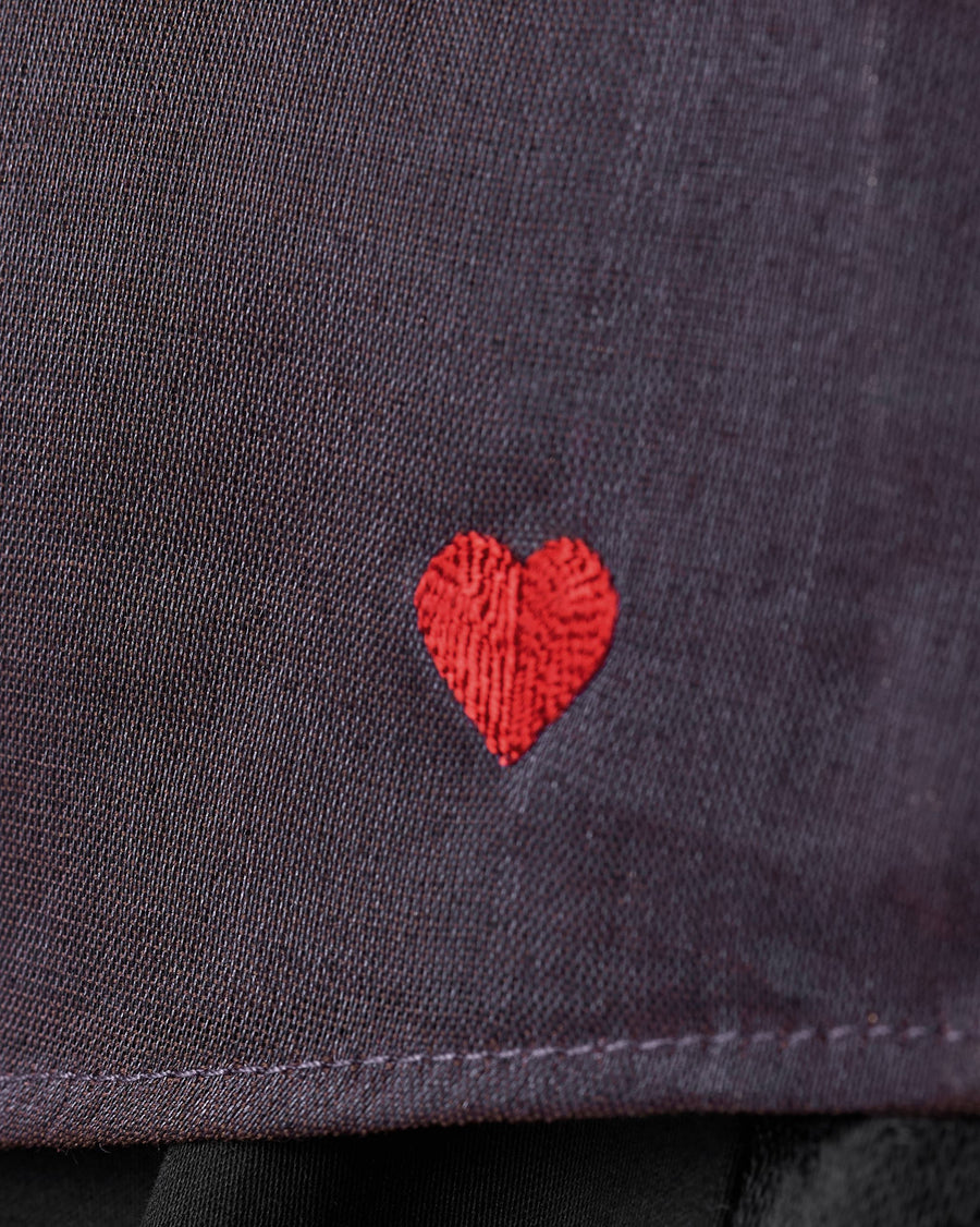 Close-up of the tiny red heart embroidered near the hem of the Sashay Top.