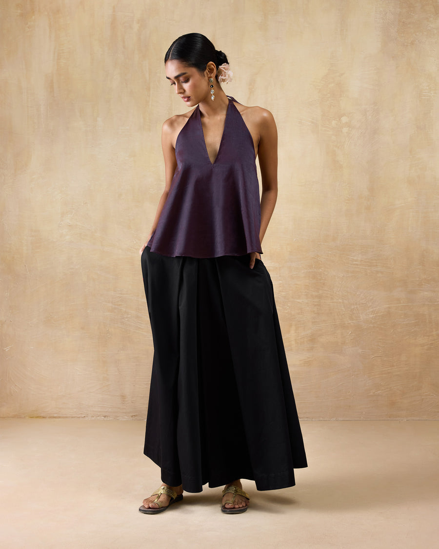 The Sashay Top worn over wide black trousers with flat sandals.