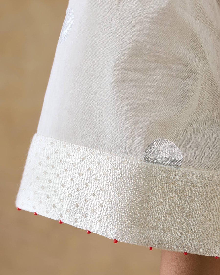 Close-up of the sleeve end of the Rejoice Kurta, finished in ivory mashru with red beads at the edge.