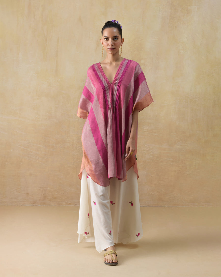 The Jhilmil Kaftan, a loose pink striped metallic tissue kaftan with a V-neck and half sleeves, worn over ivory trousers.