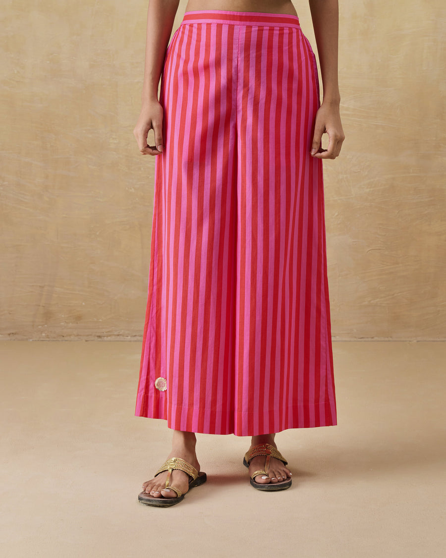 The Basic Pyjamas, wide A-line red and berry striped organic cotton voile pyjamas, worn with flat sandals.
