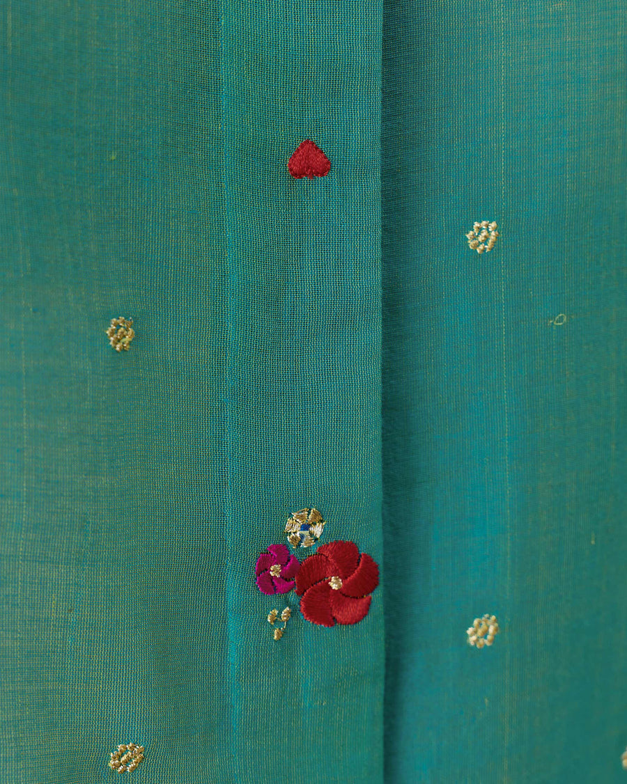 Close-up of the embroidery on the Boxy Shirt: small gold flowers and one red flower on aqua cotton silk.