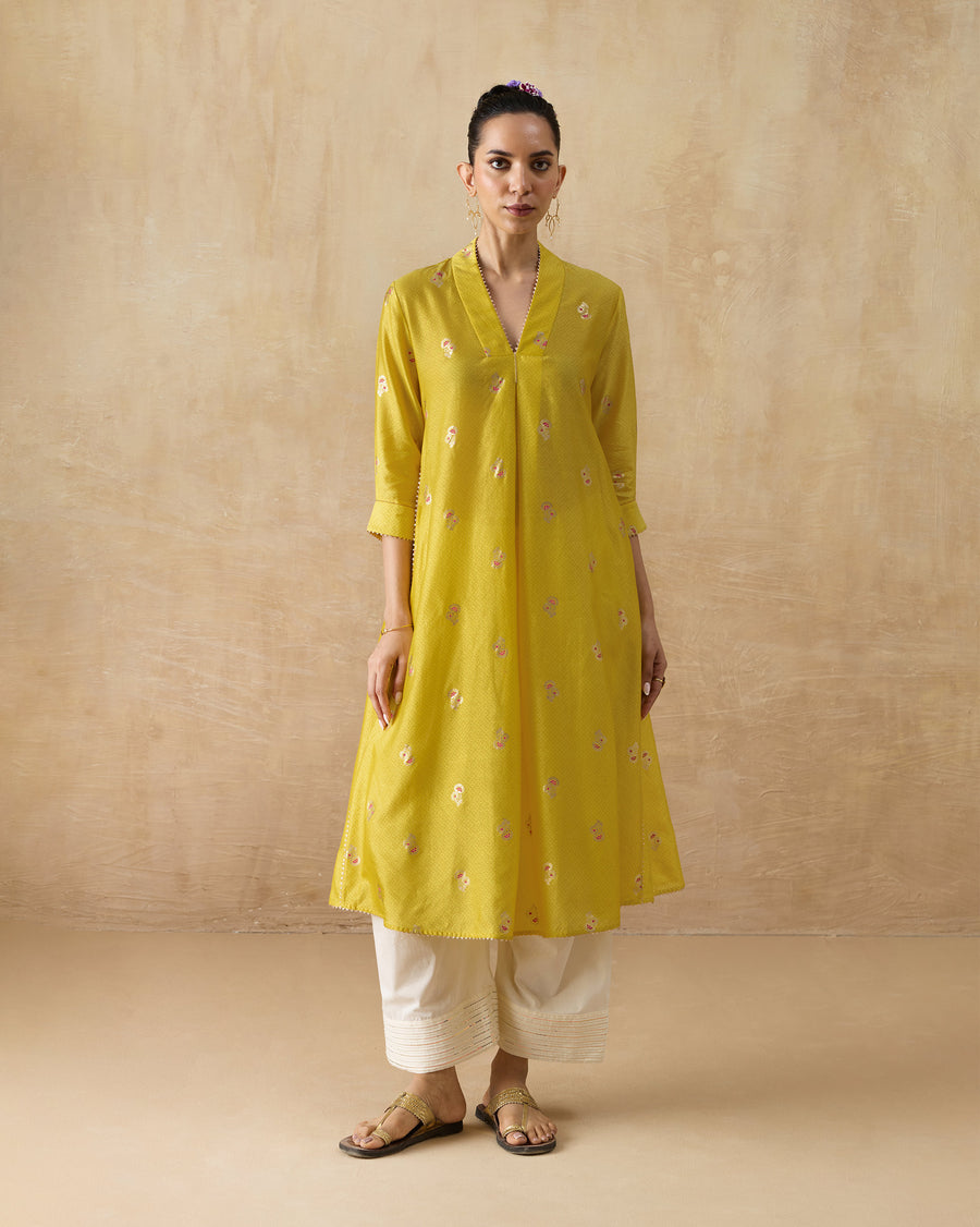 The Viva Kurta, a long chartreuse cotton silk A-line kurta with a V-neck and all-over print, worn over ivory Numa Pants.