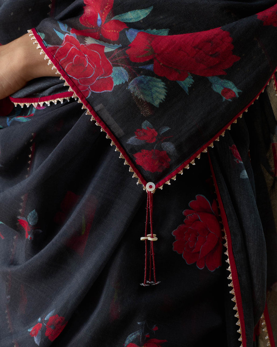Close-up of a corner of the Fizz Dupatta, with a trimmed edge and a beaded tassel over the rose print.