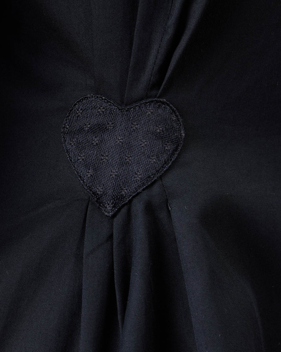 Close-up of the black heart mushru patch on the back of the Rai Top, where the pleats gather.