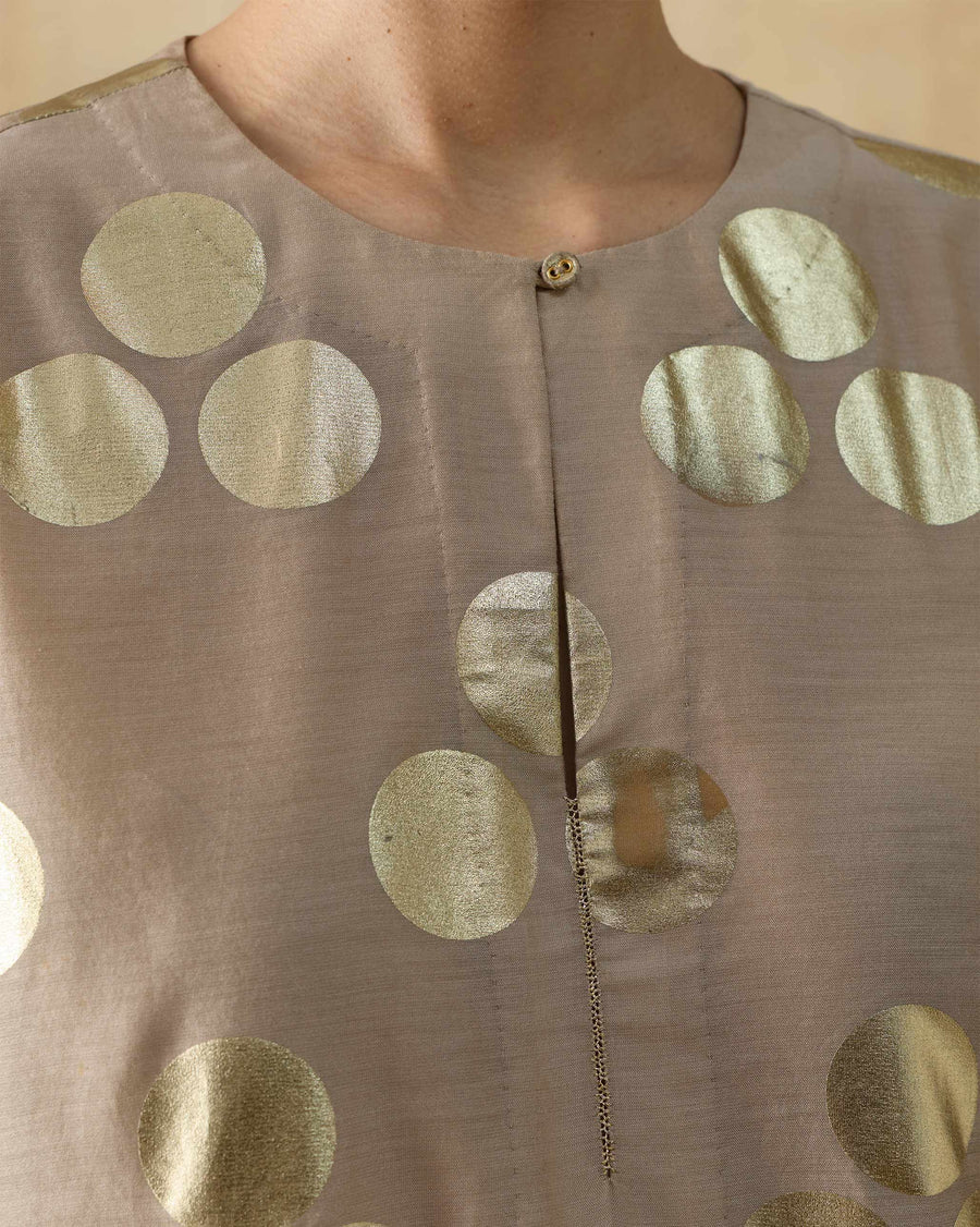 Close-up of the round neckline of the Cloud Dancer Kurta, with gold dots on sand cotton silk.