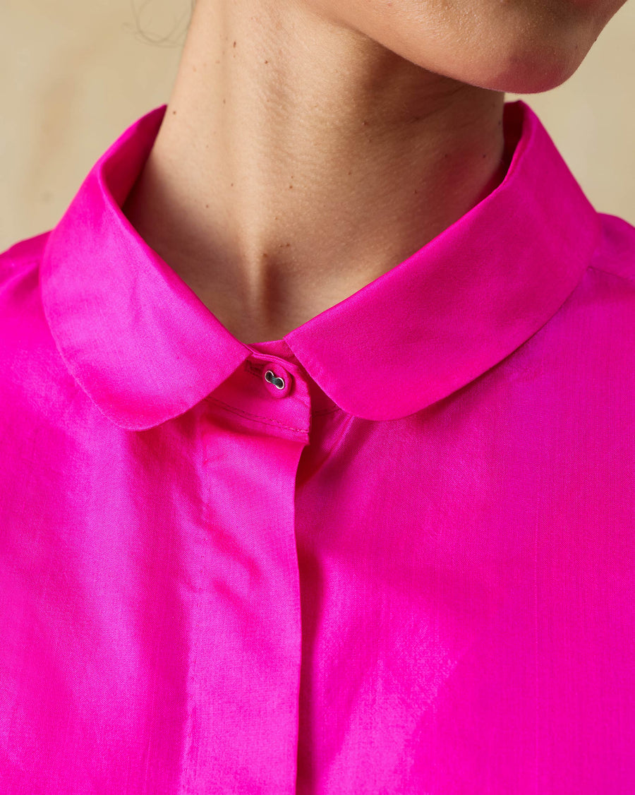 Close-up of the rounded collar and concealed placket of the Boxy Shirt in fuchsia silk.