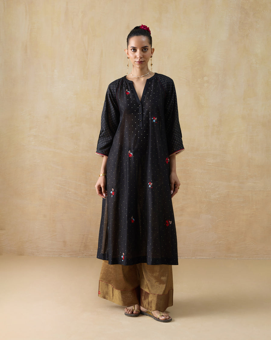 The Moonbeam Kurta, a long black cotton silk kurta with gold foil dots and multicolour embroidery, worn over gold trousers.