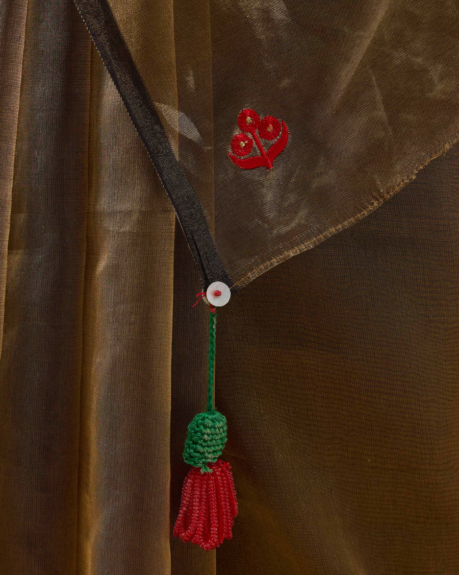 Close-up of the pallu corner of the Dancefloor Sari: a red embroidered icon and a crochet tassel.