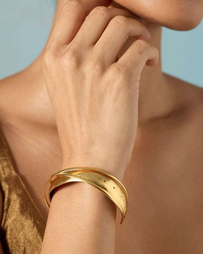 Person wearing a Kaveri Bangle with a twisted gold band on the wrist.