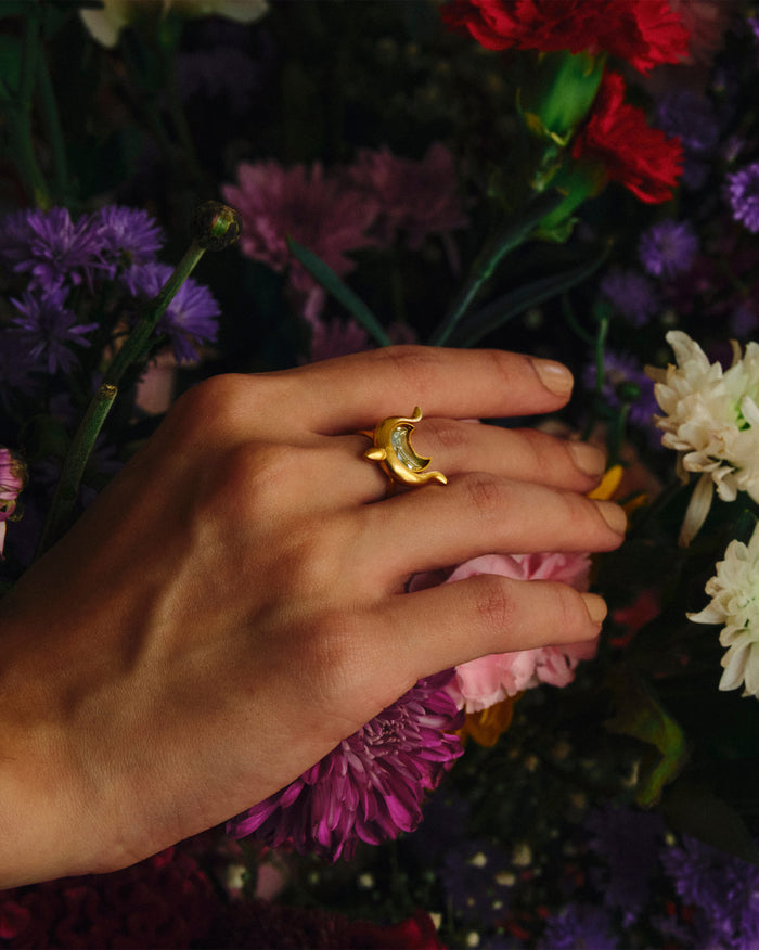 Person wearing a gold Chandphool ring with a crescent moon motif.