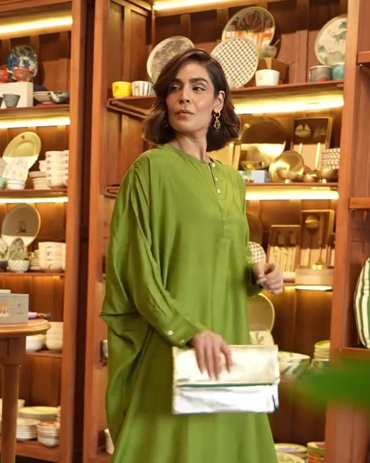 Roohi Marjara in the olive Lazy Sunday Tunic with white trousers and a silver Fold Over Clutch