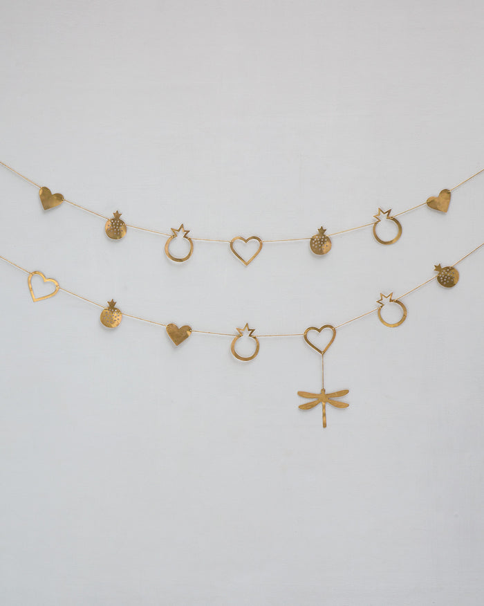 Two brass Anar Toran strands with heart, pomegranate, and dragonfly charms.