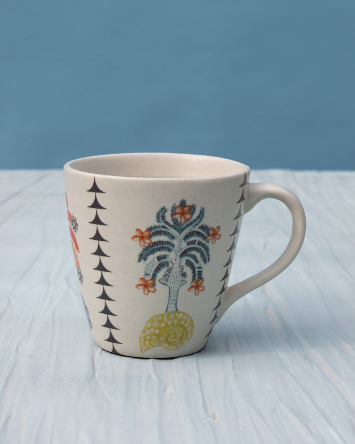 Uhuru Mug with a blue palm tree, orange flowers and a black triangle border.