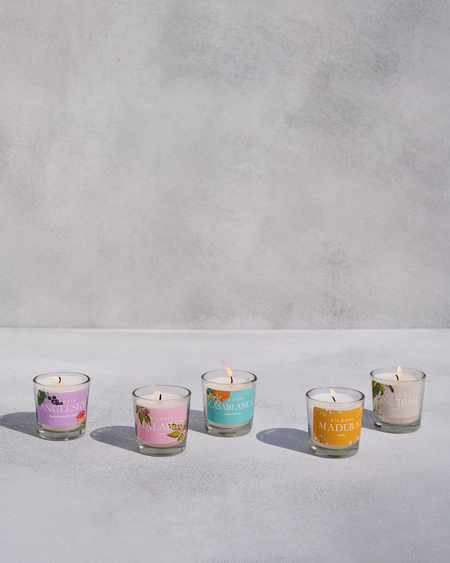 Five lit jar candles in an arc.
