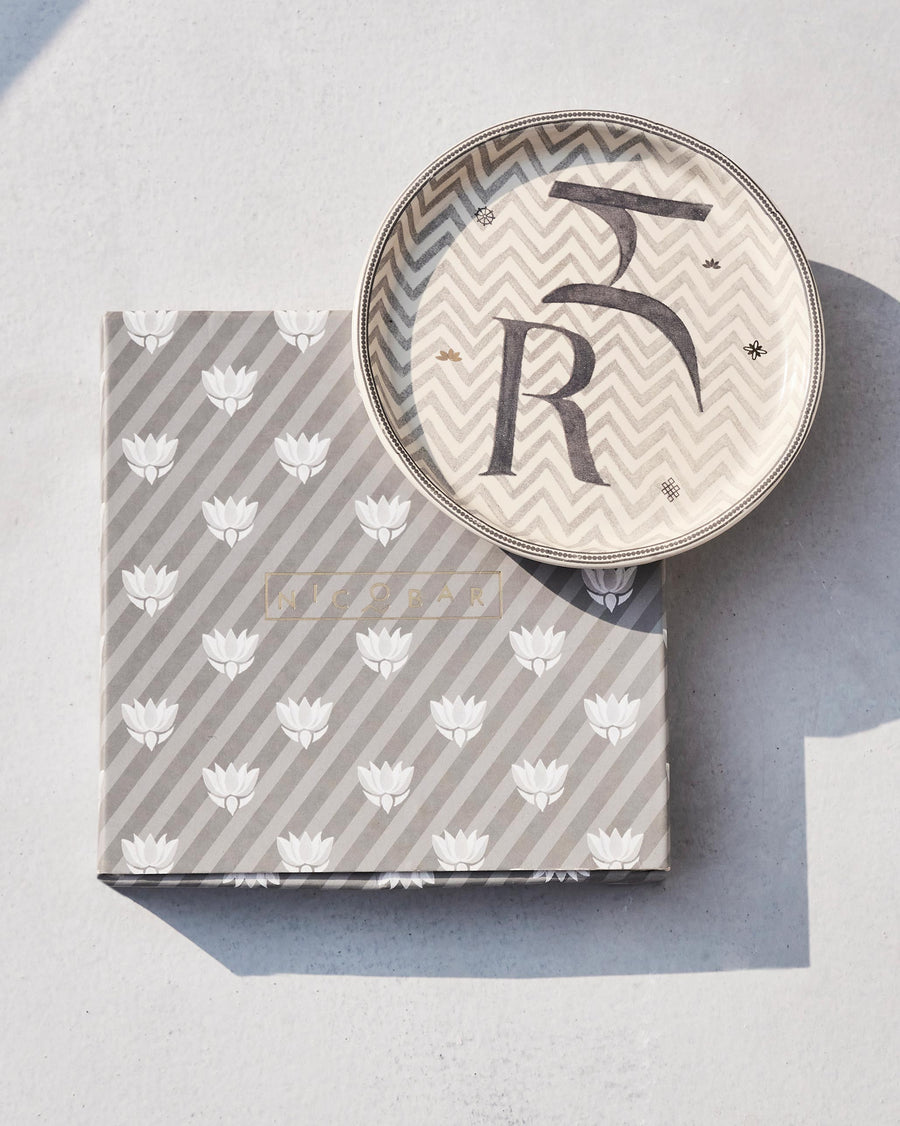 The Akshar Coaster beside its striped gift box.