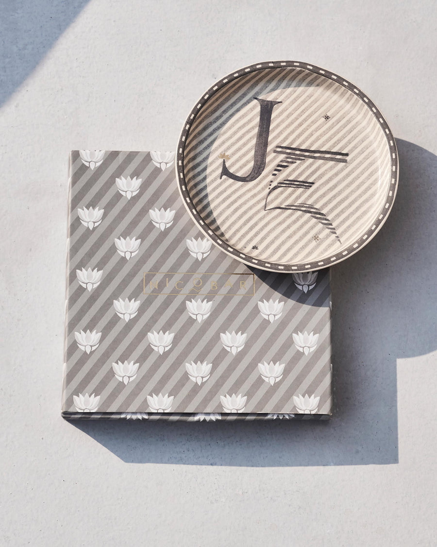 The Akshar Coaster beside its striped gift box.