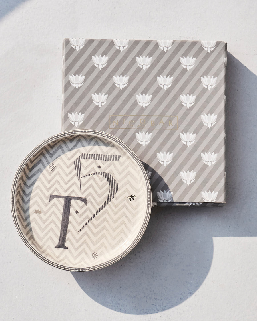 The Akshar Coaster beside its striped gift box.