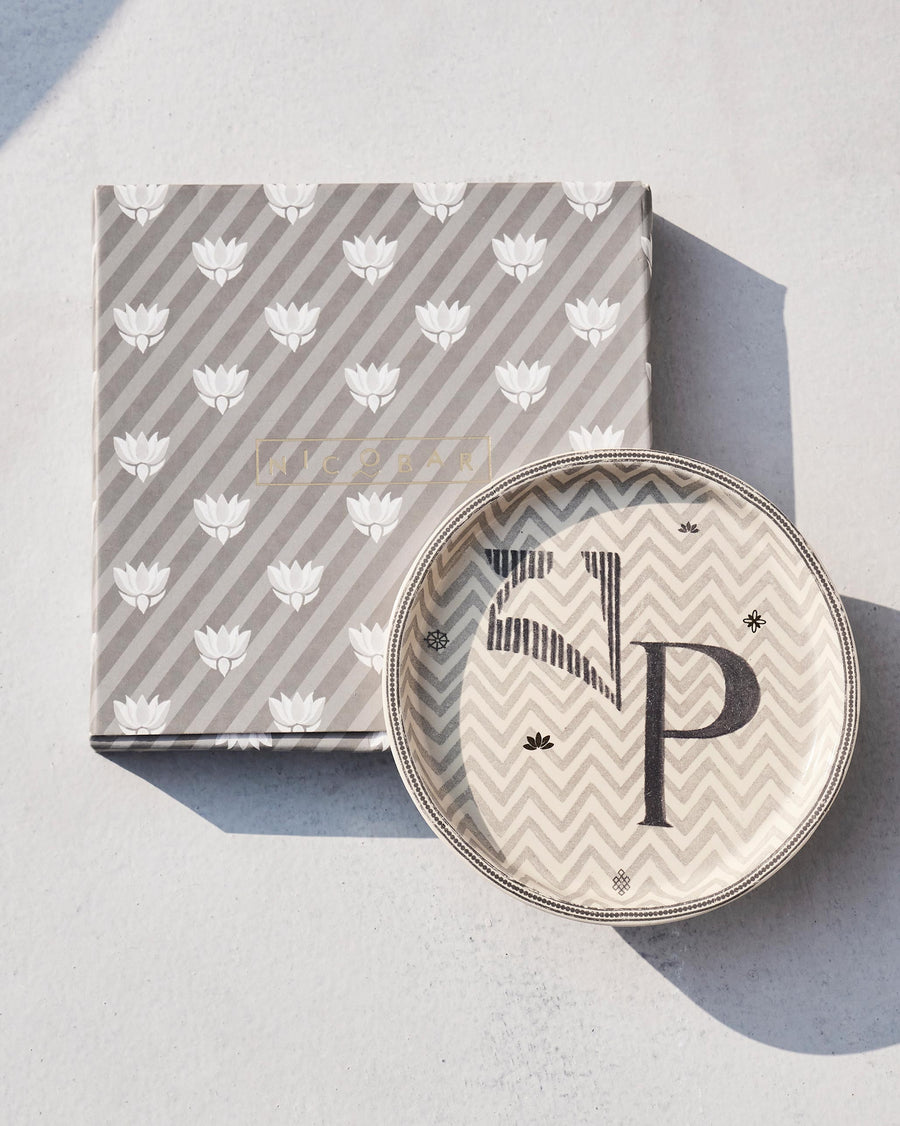 The Akshar Coaster beside its striped gift box.