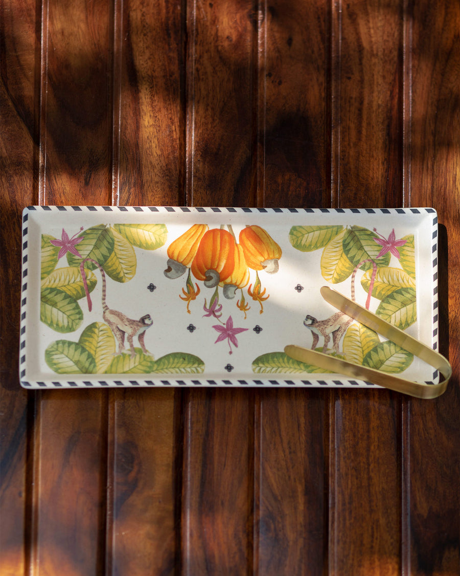 The Mahi tray with gold tongs on a dark wooden table