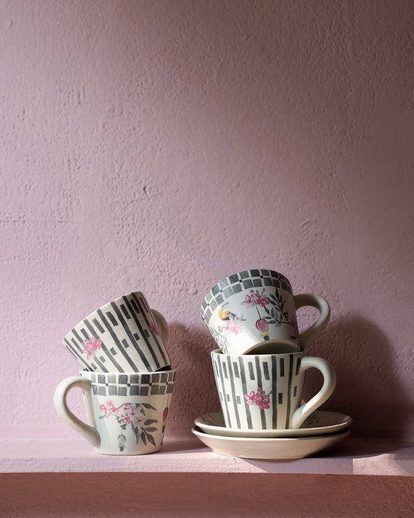Mugs stacked on a saucer showing both prints