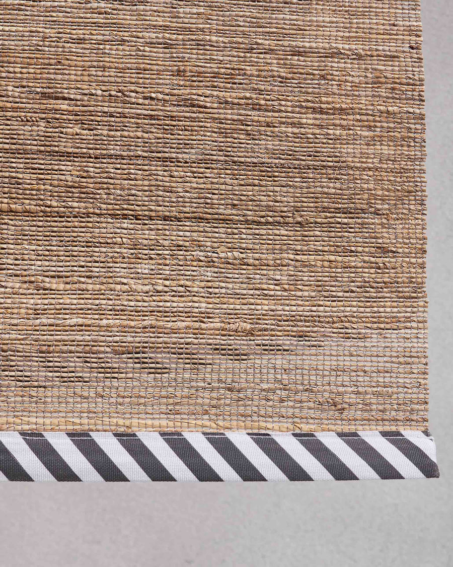 The weave meeting the striped border.