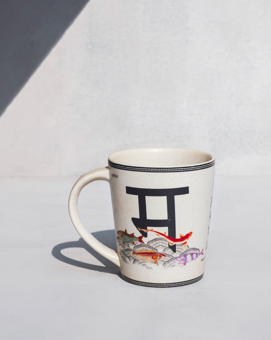 The Machli Mug side-on, showing its tapered shape and curved handle.
