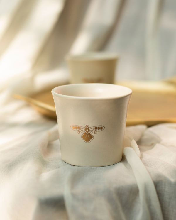 Close view of the gold fly on an ivory cup