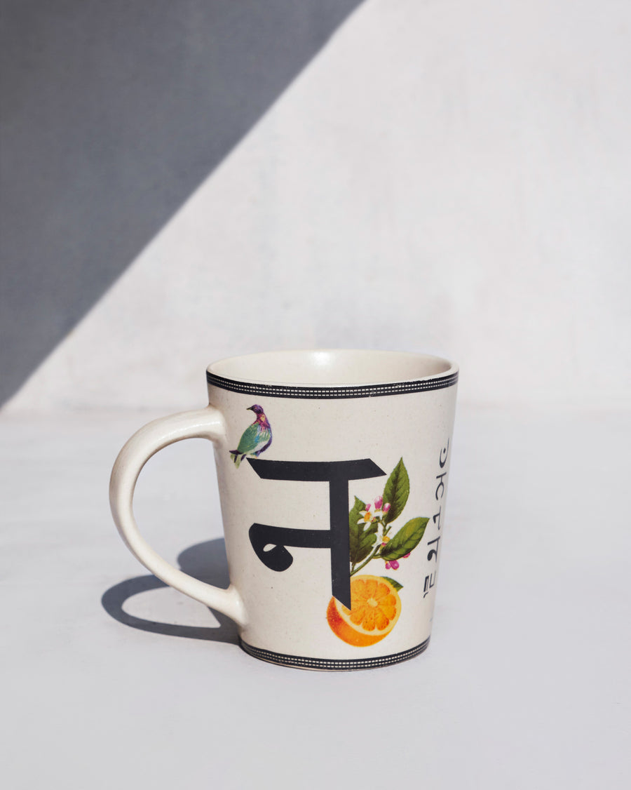 The Nico Mug side-on, showing its tapered shape and curved handle.