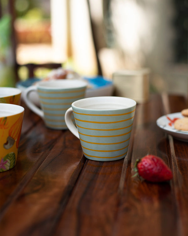 A pale blue mug with thin yellow stripes