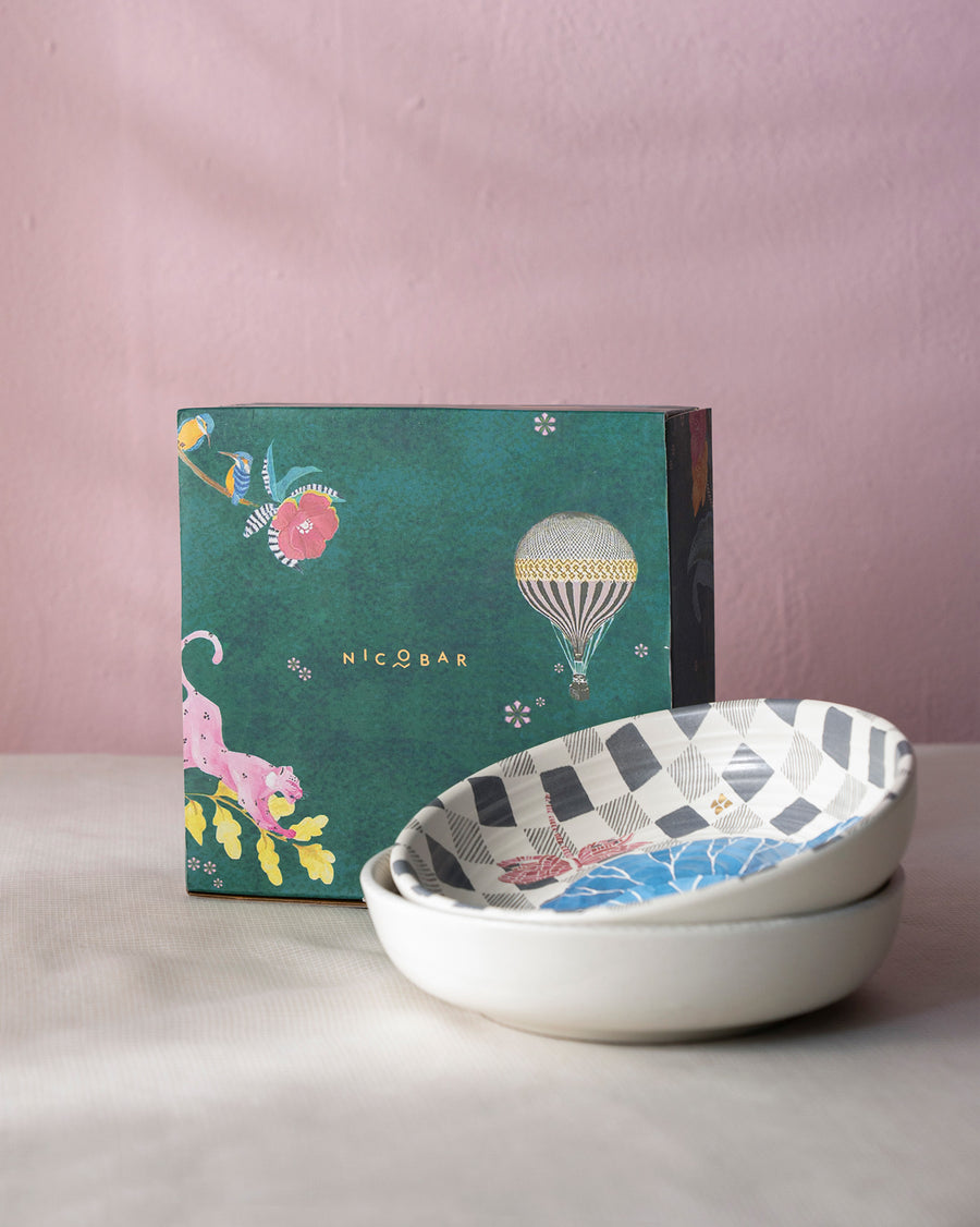 The two bowls stacked in front of a green illustrated gift box