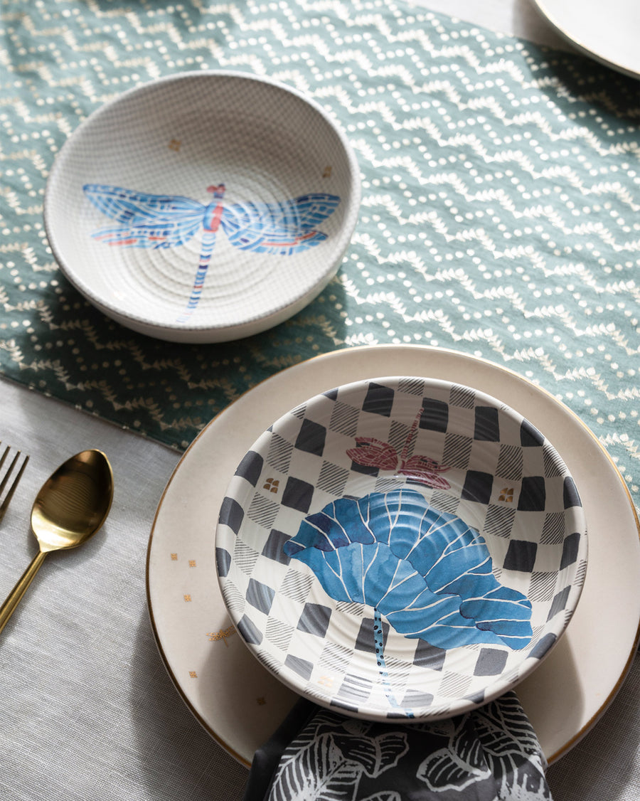 Two Nectar bowls on a table with a zigzag cloth and gold cutlery